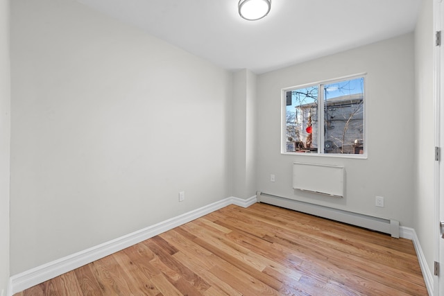 unfurnished room featuring light hardwood / wood-style floors and a baseboard radiator