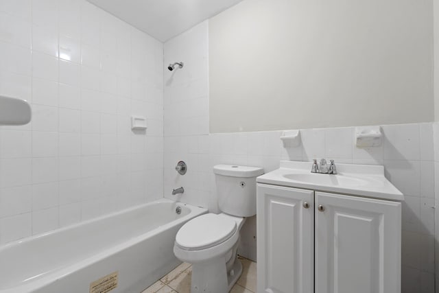 full bathroom with tile walls, toilet, vanity, and tile patterned flooring