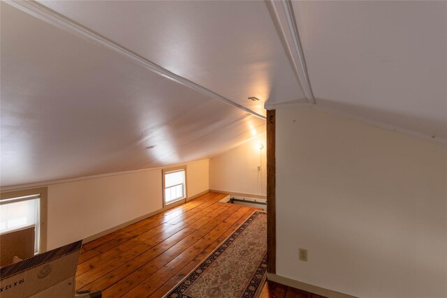 additional living space with hardwood / wood-style flooring and lofted ceiling