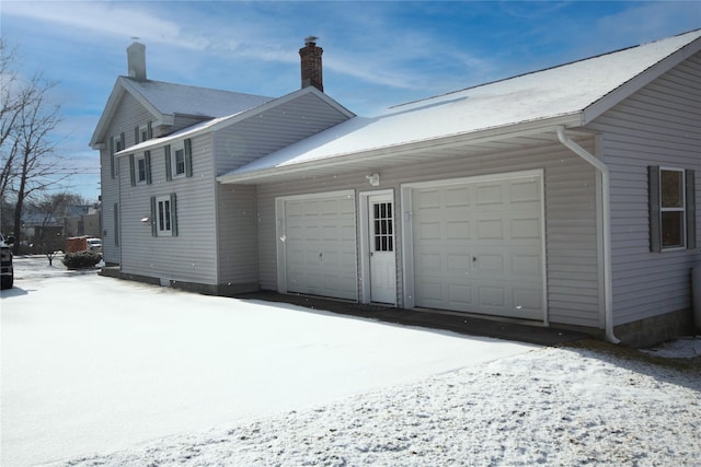 view of snowy exterior featuring a garage