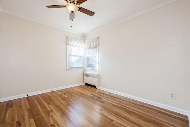 spare room featuring ceiling fan, radiator, ornamental molding, and hardwood / wood-style floors