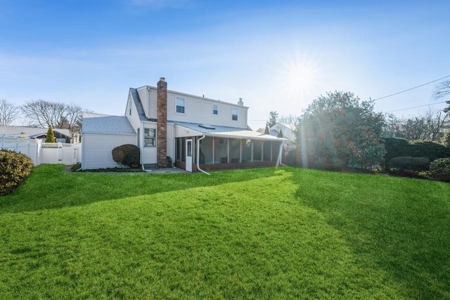 back of house with a sunroom and a yard