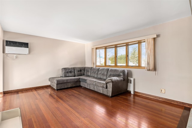 unfurnished living room featuring dark hardwood / wood-style floors, radiator, and a wall mounted air conditioner