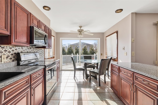 kitchen with tasteful backsplash, ceiling fan, light stone countertops, appliances with stainless steel finishes, and light tile patterned floors