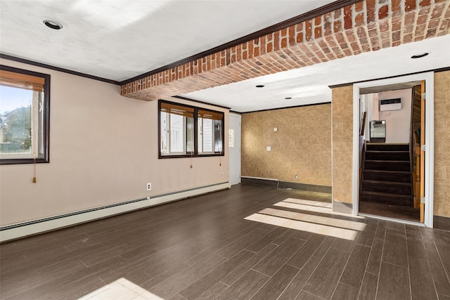 unfurnished room featuring baseboard heating, ornamental molding, and dark hardwood / wood-style floors