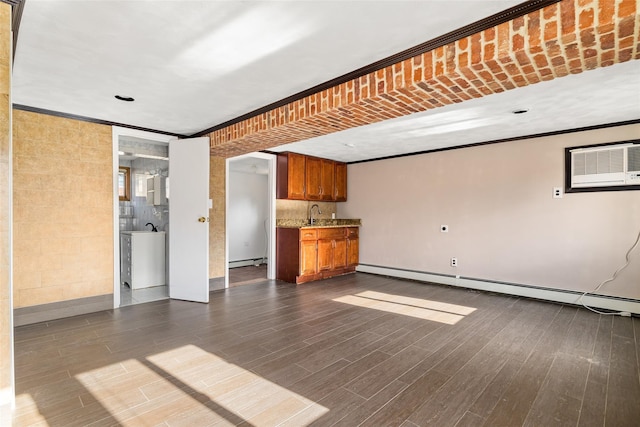 unfurnished living room featuring baseboard heating, dark hardwood / wood-style flooring, crown molding, and a wall mounted air conditioner