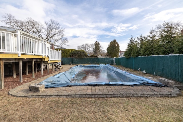 view of swimming pool with a deck and a yard