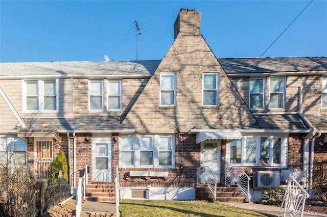 view of property featuring ac unit and a front lawn