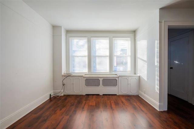 empty room with dark hardwood / wood-style flooring