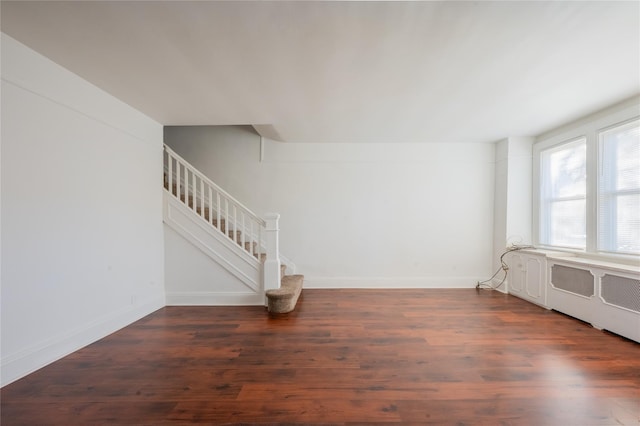 spare room featuring radiator heating unit and dark hardwood / wood-style flooring