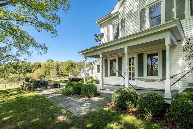 view of property exterior featuring a porch and a lawn