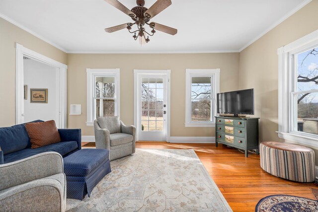 living room featuring ceiling fan, ornamental molding, and hardwood / wood-style flooring