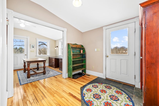 entryway with a wealth of natural light, dark hardwood / wood-style flooring, and lofted ceiling