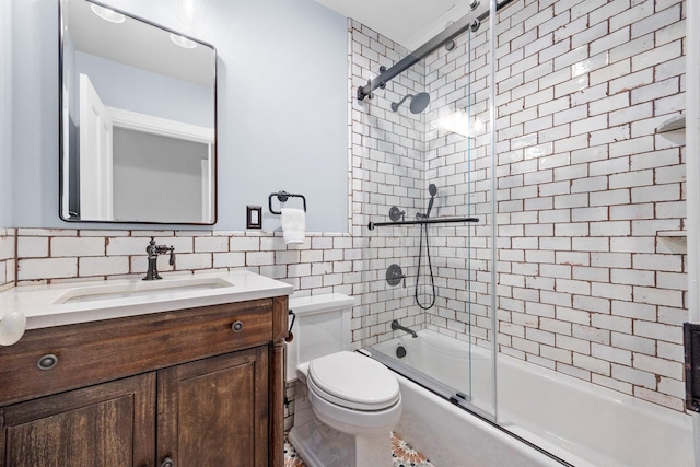 full bathroom featuring toilet, tile walls, vanity, and shower / bath combination with glass door