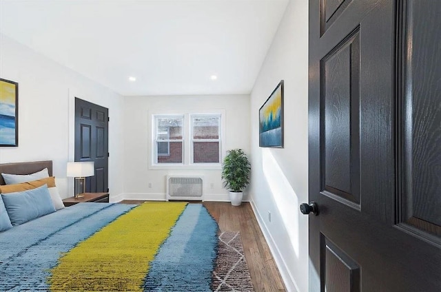 bedroom with dark hardwood / wood-style flooring and heating unit