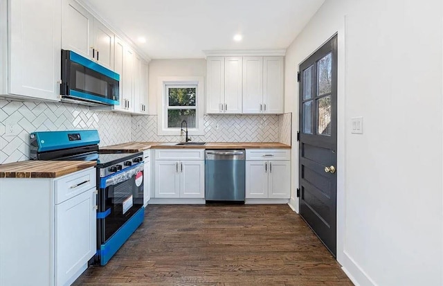 kitchen with sink, dark hardwood / wood-style flooring, stainless steel appliances, white cabinets, and butcher block counters