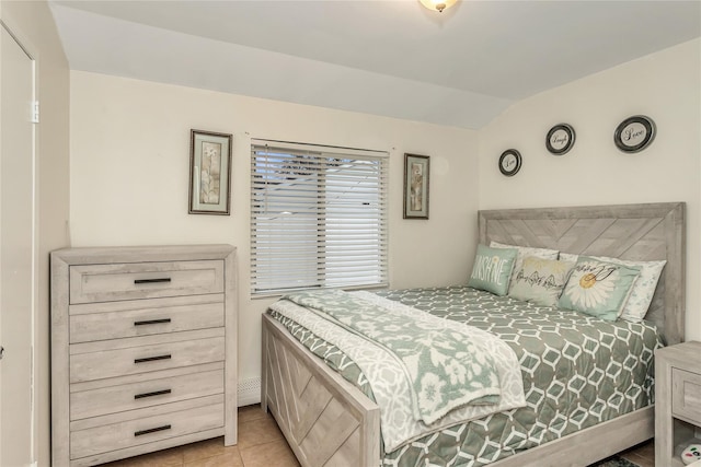 tiled bedroom featuring vaulted ceiling