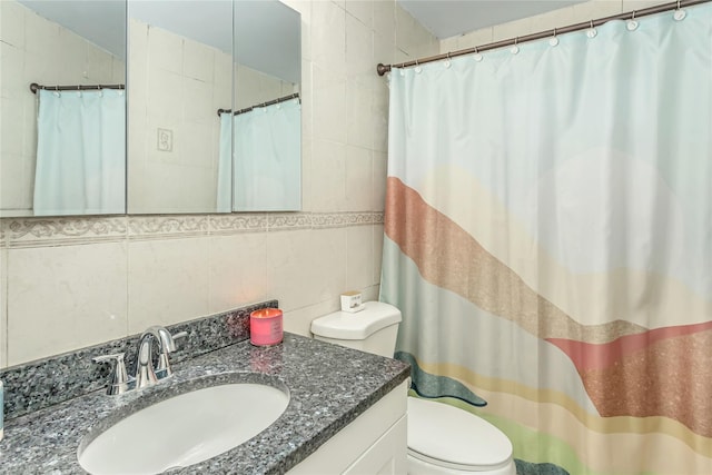 bathroom with toilet, tile walls, backsplash, and vanity