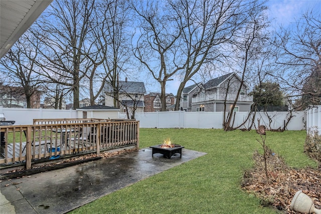 view of yard with a deck and an outdoor fire pit