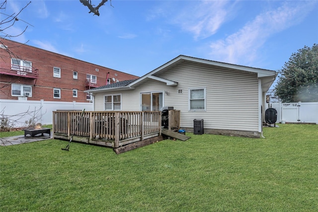 rear view of house with a yard and a wooden deck