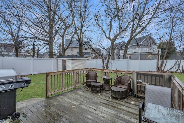 deck with a grill, a yard, and a shed