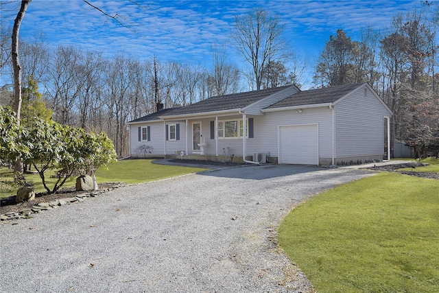 ranch-style home featuring a front lawn, a garage, and ac unit