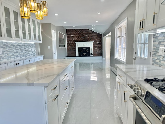 kitchen featuring hanging light fixtures, glass insert cabinets, white cabinetry, vaulted ceiling, and a kitchen island