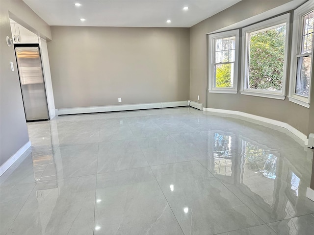 unfurnished room with a baseboard heating unit, recessed lighting, and baseboards