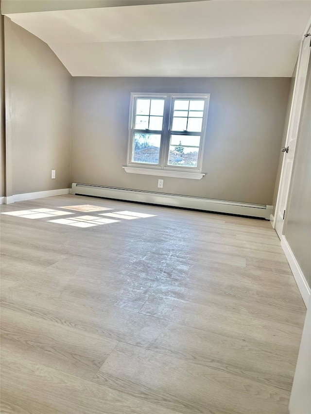 unfurnished room featuring a baseboard heating unit and baseboards