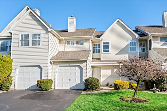 view of property with a front lawn and a garage