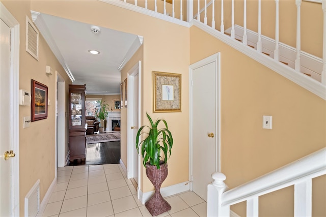 hall featuring ornamental molding and light tile patterned flooring