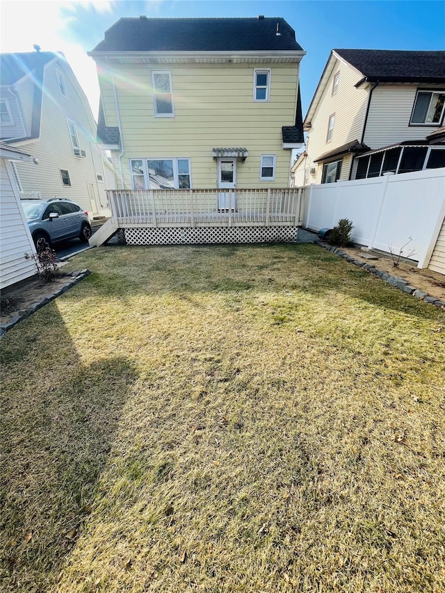 rear view of property with a lawn and a deck