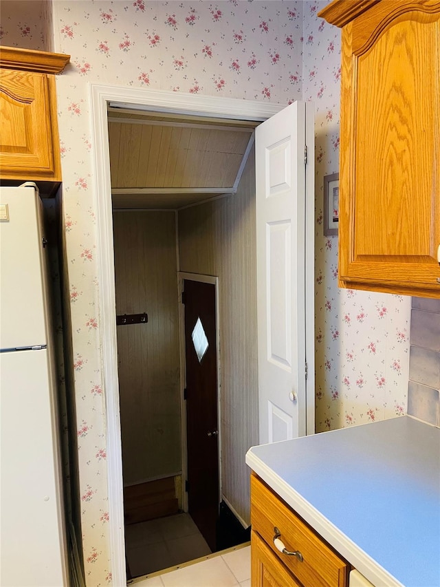 kitchen with light tile patterned floors and white fridge