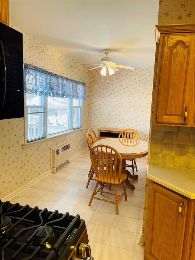 dining space featuring ceiling fan and radiator heating unit