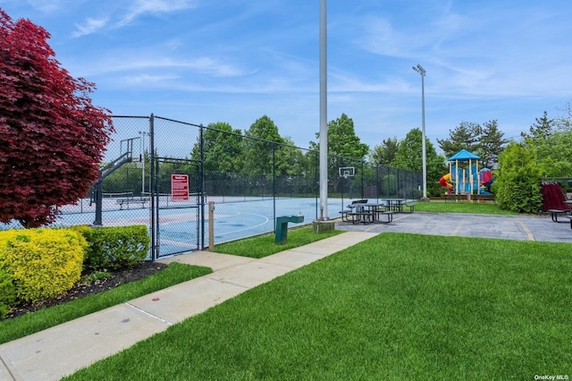 view of sport court with a playground, tennis court, and a lawn