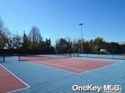 view of tennis court with basketball hoop