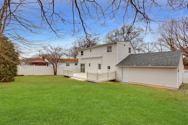 back of property featuring a wooden deck and a lawn