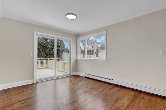 empty room with hardwood / wood-style flooring and a baseboard heating unit