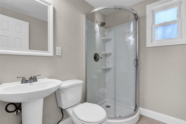 bathroom with a shower with door and toilet