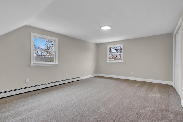 interior space with baseboard heating, vaulted ceiling, and carpet flooring