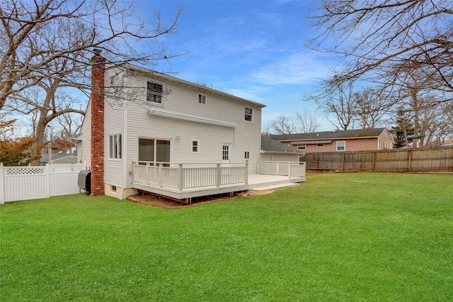 back of property featuring a lawn and a wooden deck