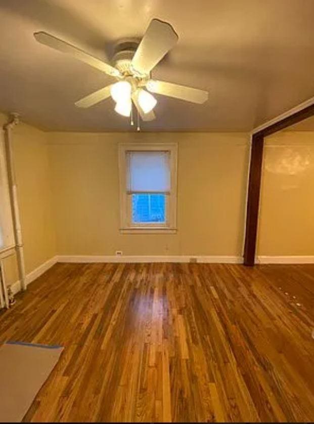 empty room featuring ceiling fan and hardwood / wood-style floors