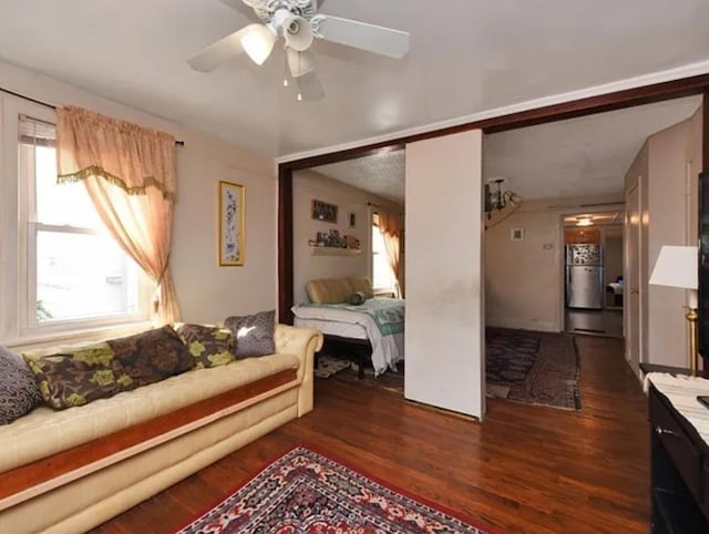 bedroom featuring ceiling fan, dark hardwood / wood-style flooring, and refrigerator