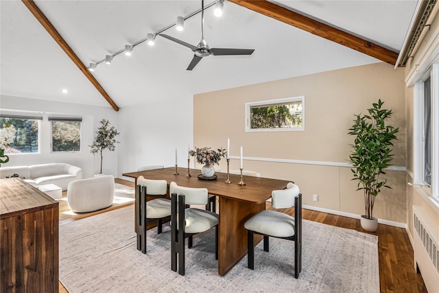 dining room with ceiling fan, radiator, hardwood / wood-style flooring, and vaulted ceiling with beams