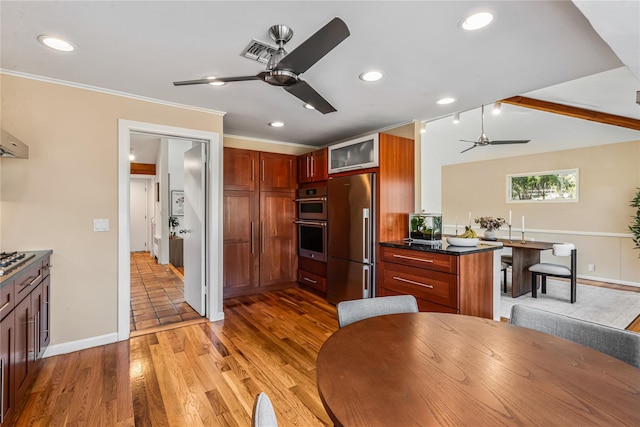 kitchen featuring ceiling fan, wood-type flooring, appliances with stainless steel finishes, and crown molding