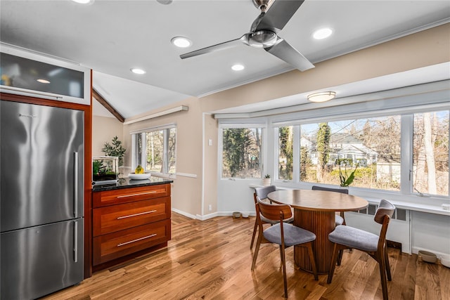 dining room featuring a healthy amount of sunlight, lofted ceiling, light hardwood / wood-style floors, and ceiling fan