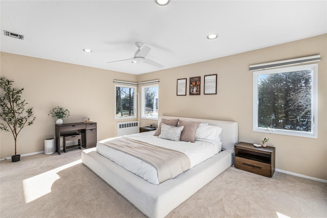 bedroom with radiator, ceiling fan, and light carpet