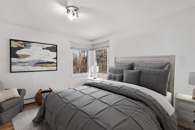 bedroom with hardwood / wood-style flooring and a baseboard radiator