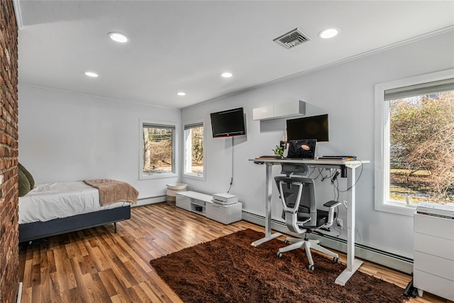 bedroom featuring baseboard heating, ornamental molding, and wood-type flooring