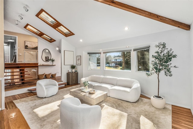 living room with vaulted ceiling with skylight, wood finished floors, and recessed lighting